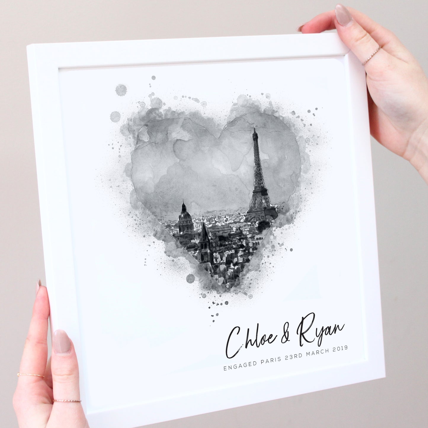 black and white illustration of eiffel tower in white frame with hands